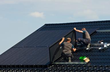Men installing solar panels on a roof in Wallonia