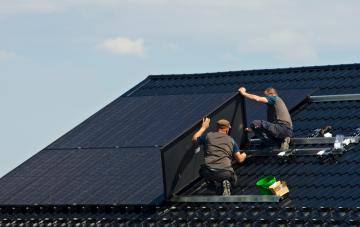 Men installing solar panels on a roof in Wallonia