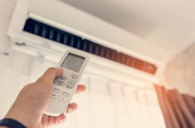 Climatisation main qui active avec une télécommande sa climatisation