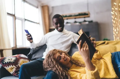 young couple on a couch checking energy bill