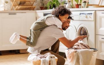Homme et enfant remplissant la machine à laver de linge