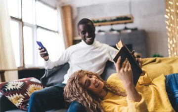 young couple on a couch checking energy bill