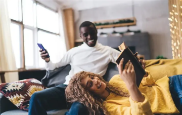 young couple on a couch checking energy bill