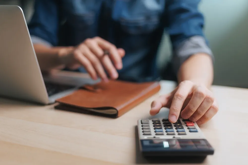 un homme qui fait le calcul pour savoir si le contrat  d'énergie dynamique est un choix judicieux