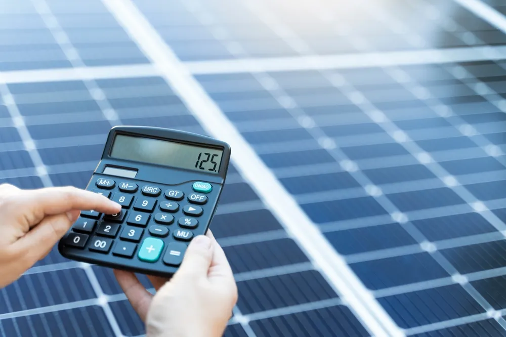 Iemand die de rentabiliteit van zonnepanelen berekent met een dynamisch energiecontract